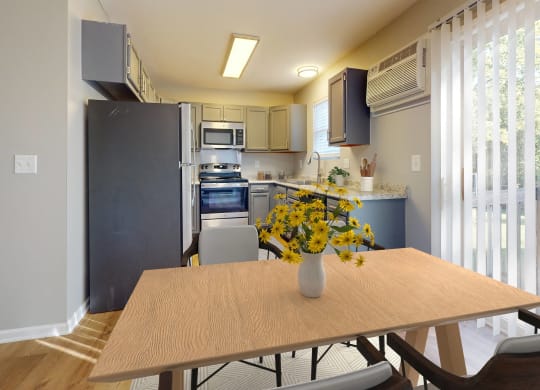 a kitchen with stainless steel appliances and a table with yellow flowers
