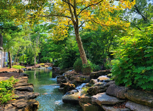 a stream running through a park with rocks and trees at Harpers Point Apartments, Ohio, 45249
