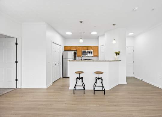 A kitchen with a bar stool in front of it.
