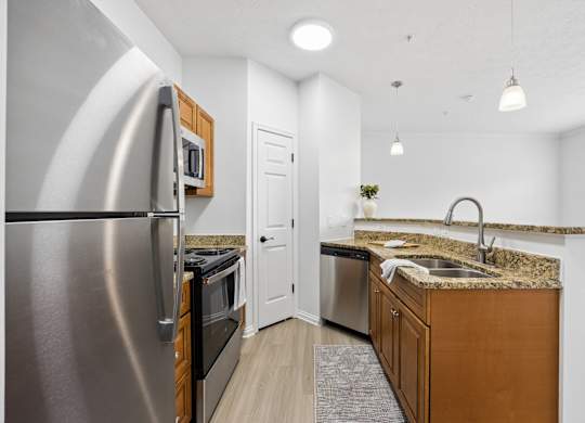 A modern kitchen with a stainless steel refrigerator and wooden cabinets.
