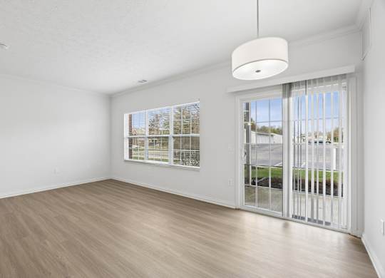 A room with a sliding glass door leading to a balcony.