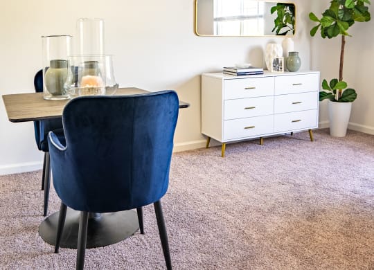 a dining room with a table and chairs and a mirror on the wall