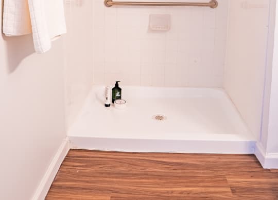 a small bathroom with a shower and a towel rack and a tub