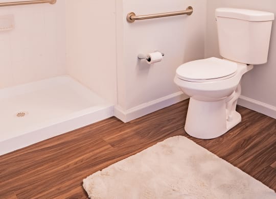 a white bathroom with a toilet and a shower