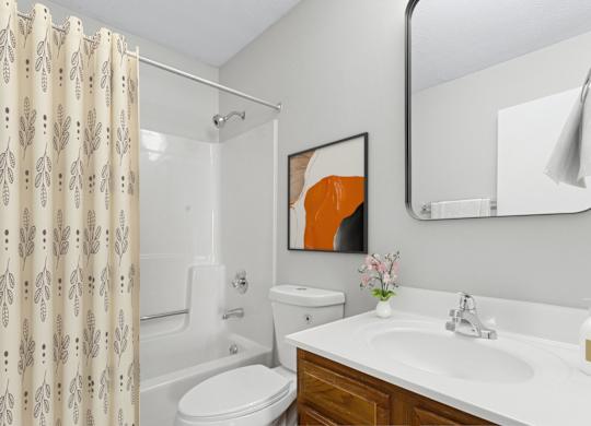 A bathroom with a toilet, sink, and shower.