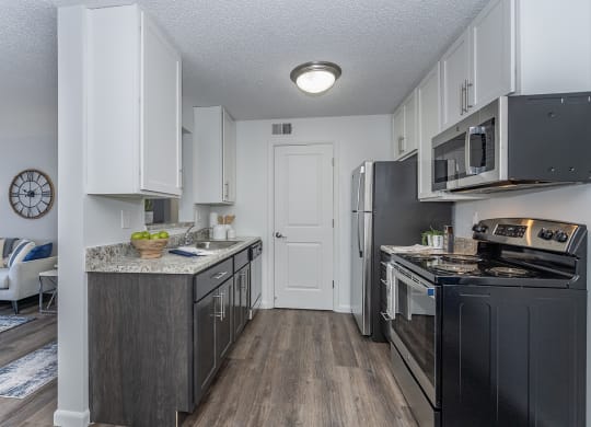 an open kitchen with black appliances and white cabinets