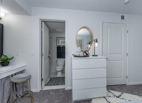 a white bathroom with a toilet and a vanity with a mirror