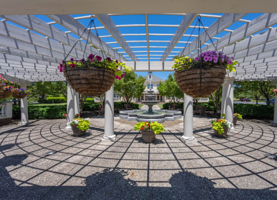 a courtyard with two hanging baskets of flowers and a fountain at Bishops Gate, Cincinnati