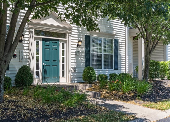 a white house with a green door and a front porch at Bishops Gate, Cincinnati