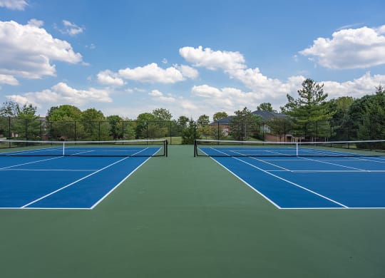 two tennis courts with blue and green surfaces on a sunny day at Bishops Gate, Cincinnati, 45249