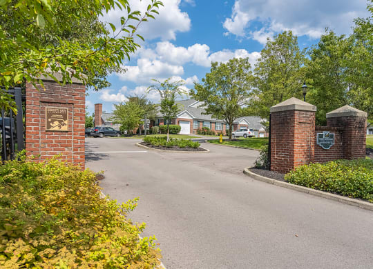 an empty street in a neighborhood with brick pillars and a gate at Bishops Gate, Ohio, 45249