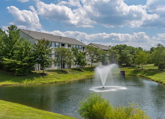 a fountain in the pond with a building in the background at Bishops Gate, Cincinnati