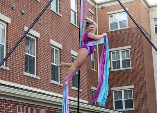 a woman hanging from a pole in front of a brick building at Roebling Row, Kentucky, 41011-1720