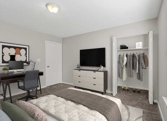 A bedroom with a bed, desk, and closet.