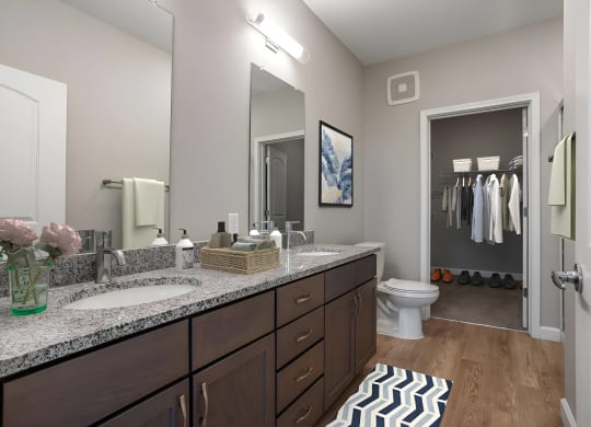 a bathroom with two sinks and a toilet and a mirror at Adelphi Quarter, Columbus