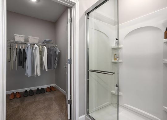 a walk in closet with a glass shower and some clothes on a rack at Adelphi Quarter, Columbus, OH