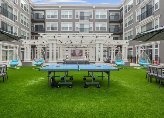 a ping pong table in front of an apartment building