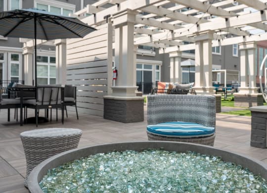 a patio with a jacuzzi and tables with chairs and umbrellas