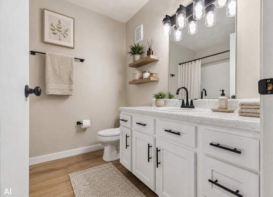 A white bathroom with a towel rack and a mirror.