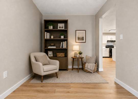 A living room with a chair, a table, and a bookshelf.