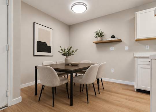 A dining room with a table and chairs.