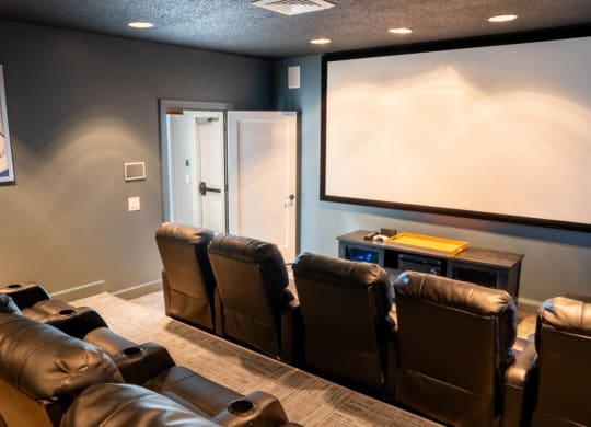 Screening room with leather chairs and a projector screen at Waterstone Landing, Ohio