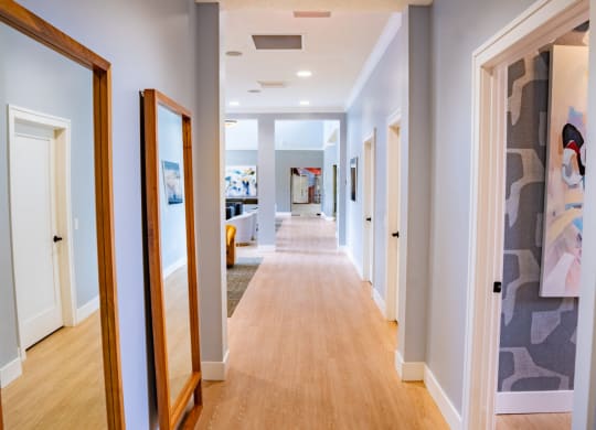Long hallway with mirrors on the wall and a long wood floor at Waterstone Landing, Perrysburg, OH