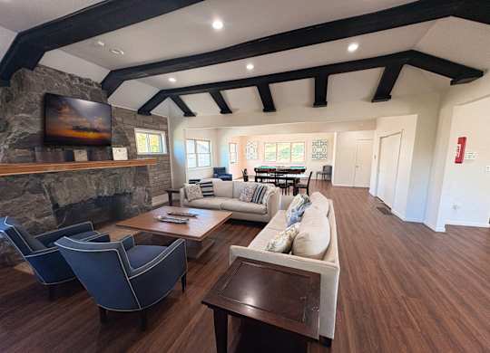 A living room with a stone fireplace and a large couch.
