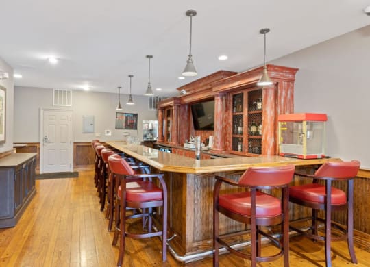 a large bar in a kitchen with red bar stools