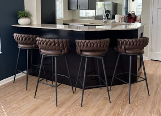 a kitchen with a counter top and some chairs