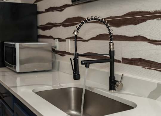a kitchen sink with a faucet and a microwave on the counter at Monmouth Row Apartments, Newport, 41071
