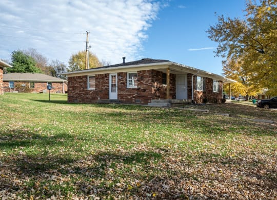 a small brick house with a lawn in front of it at Stonebrook of Franklin, Franklin