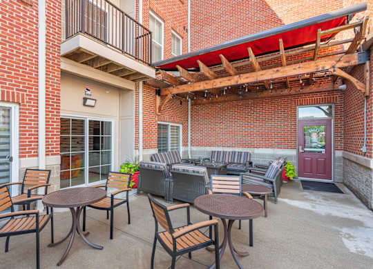 A patio with a table and chairs is surrounded by a brick building.