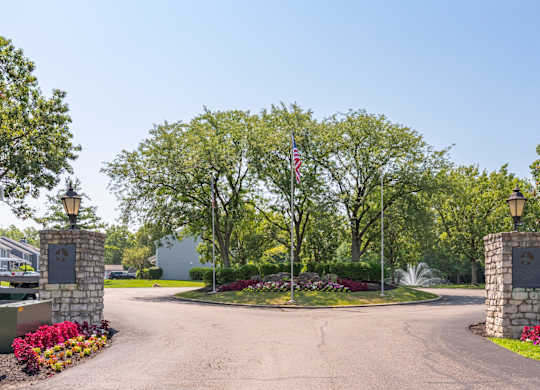 A driveway leads to a house with a flag on a pole.