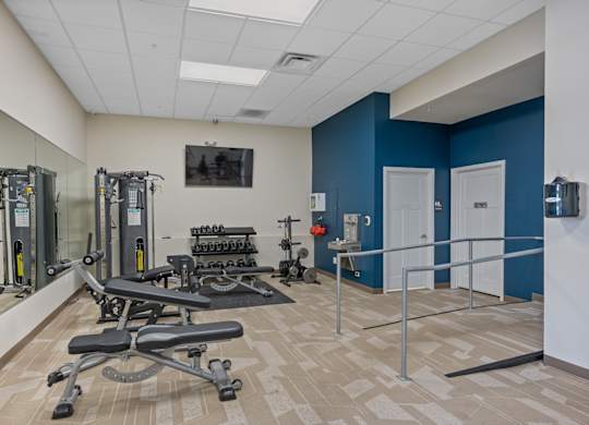 A gym with a blue wall and a mirror.