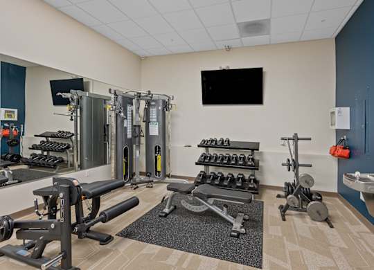 A gym with a variety of equipment including weights and machines.