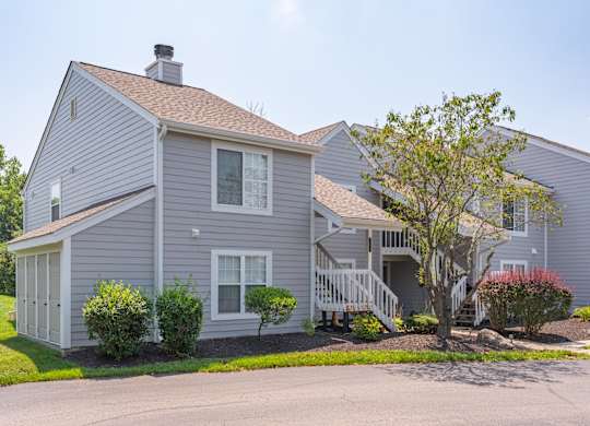 A house with a grey siding and a brown roof.
