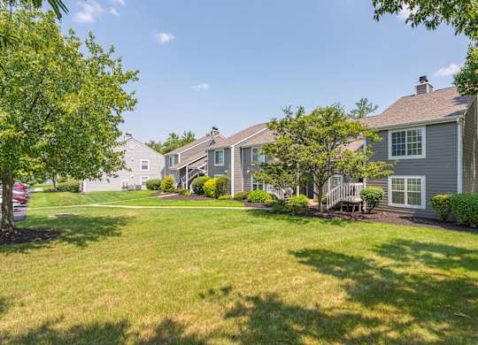 A sunny day in a residential area with houses and green lawns.
