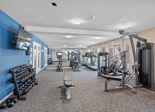 A gym with a variety of equipment including weights and machines.