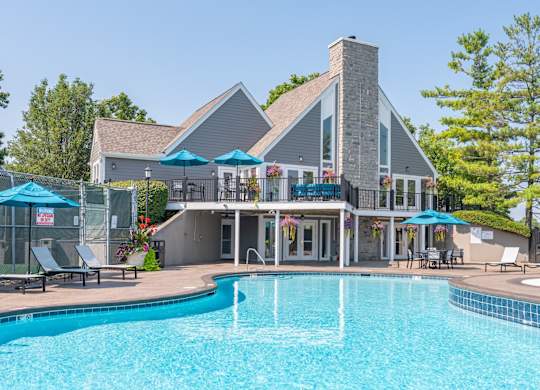 A large house with a pool in front.
