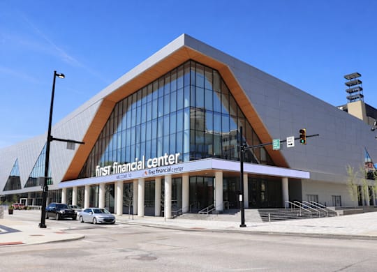 A large building with a curved glass facade and a sign that reads "First Financial Center.".