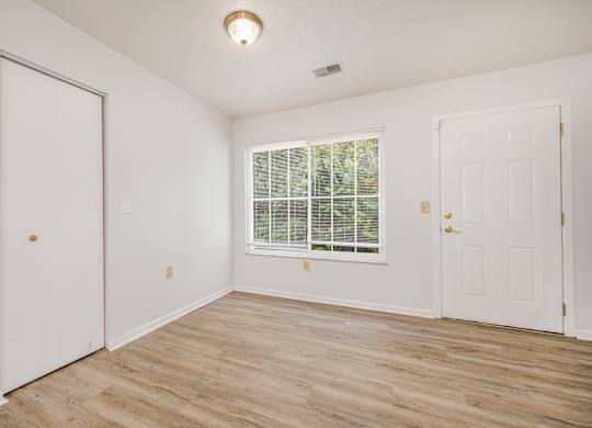 A room with a window and two doors.