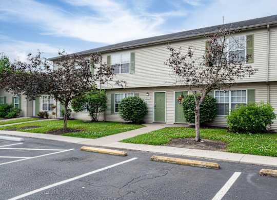 Apartment building with a parking lot in front.