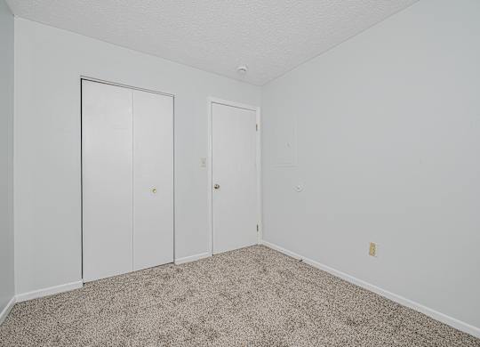 A room with two doors and a carpeted floor.