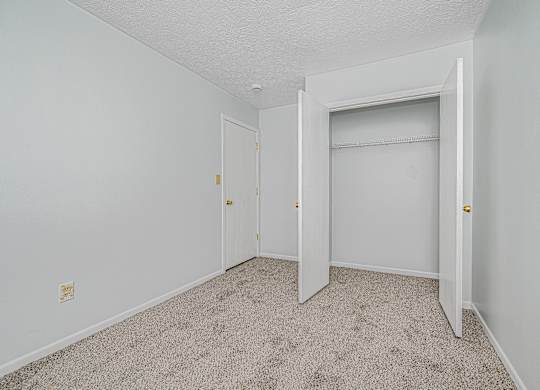 A white room with a carpeted floor and two doors.