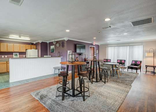 a living room with a dining area and a kitchen with a table and chairs