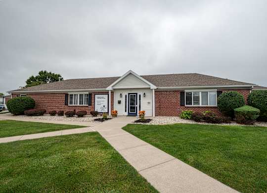 a brick house with a sidewalk in front of it