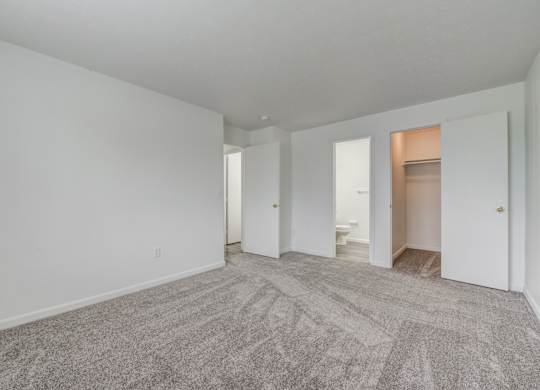 an empty living room with white walls and carpet
