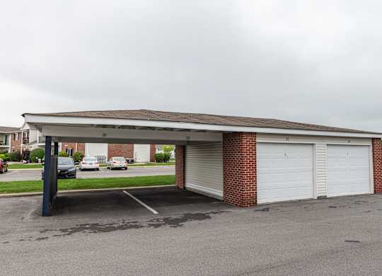 a parking lot with a white garage with a roof