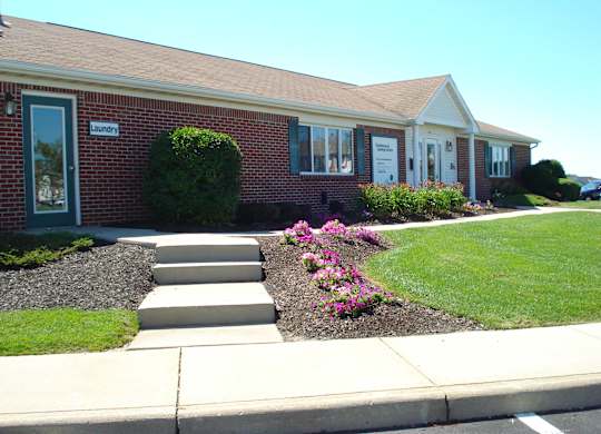 the front of a house with steps leading up to the front yard
